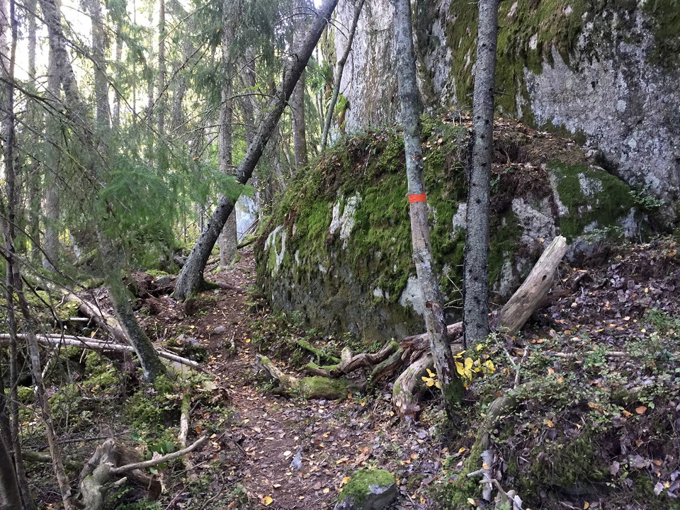 Stig längs med brant klippvägg.
