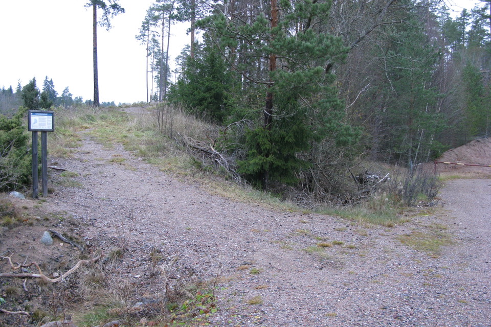 En bred stig går uppför en ås. Vid början av stigen står en informationsskylt.