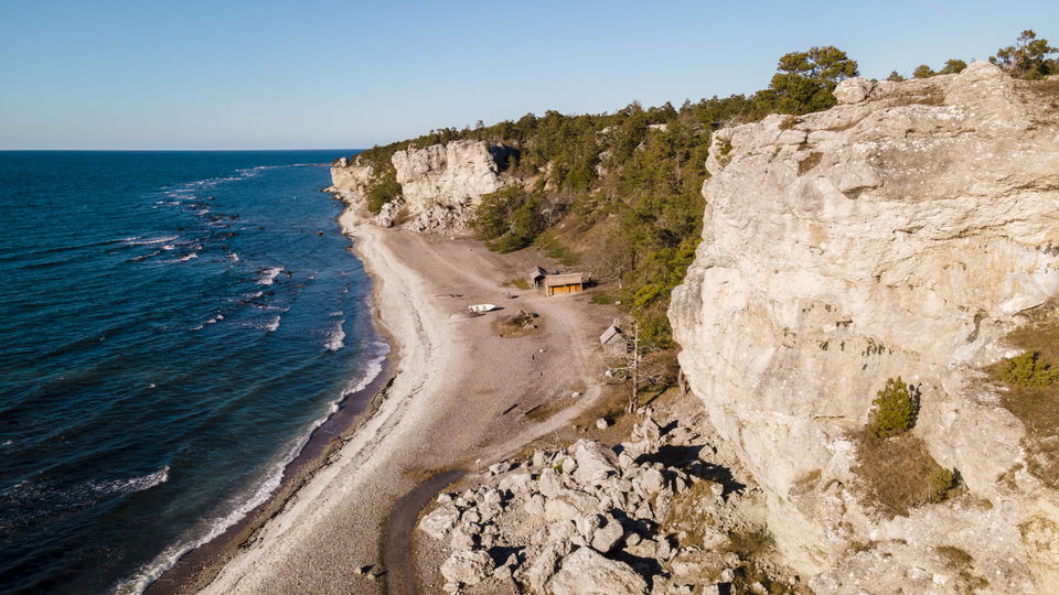 Översiktsbild över stenstrand och klintkant.