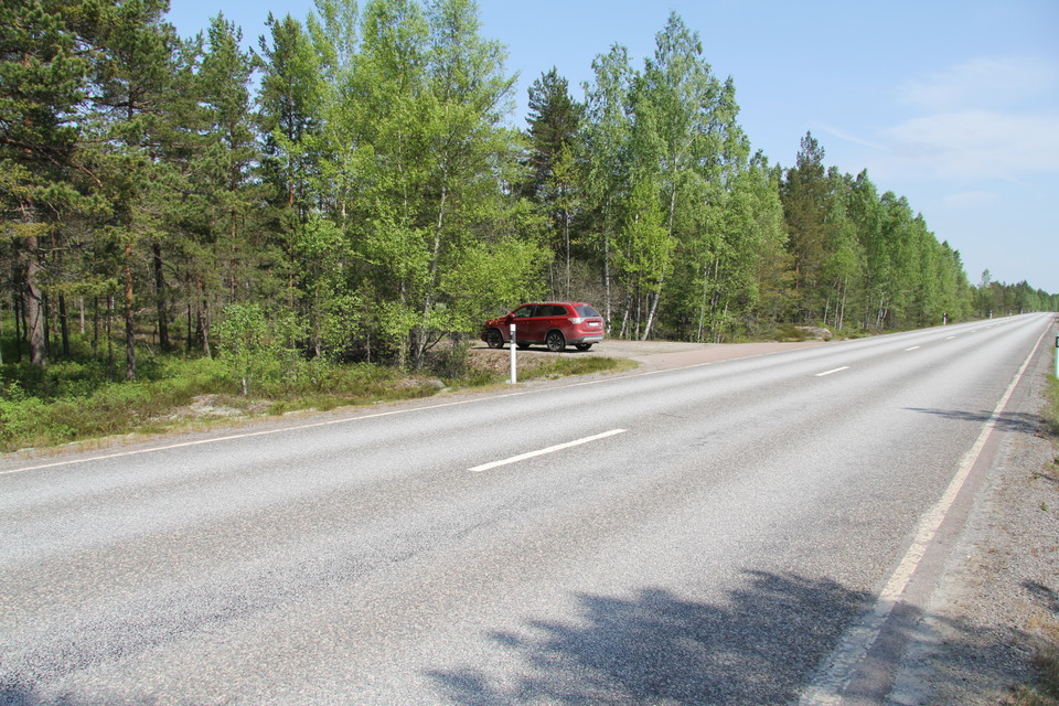 Parkering på grusplan intill landsvägen.