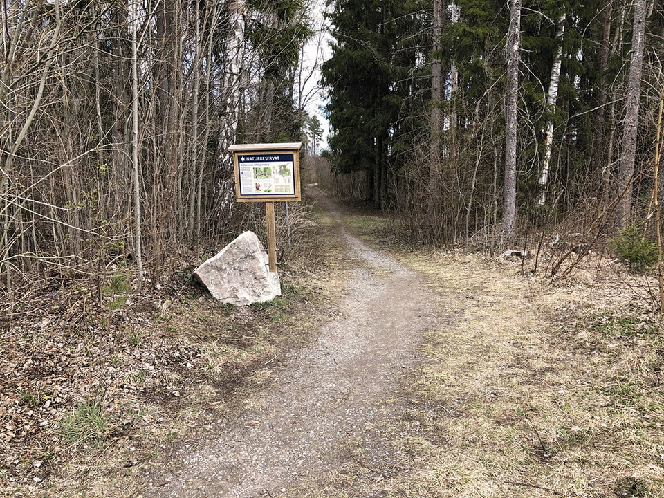 Informationstavla vid grusad stig.
