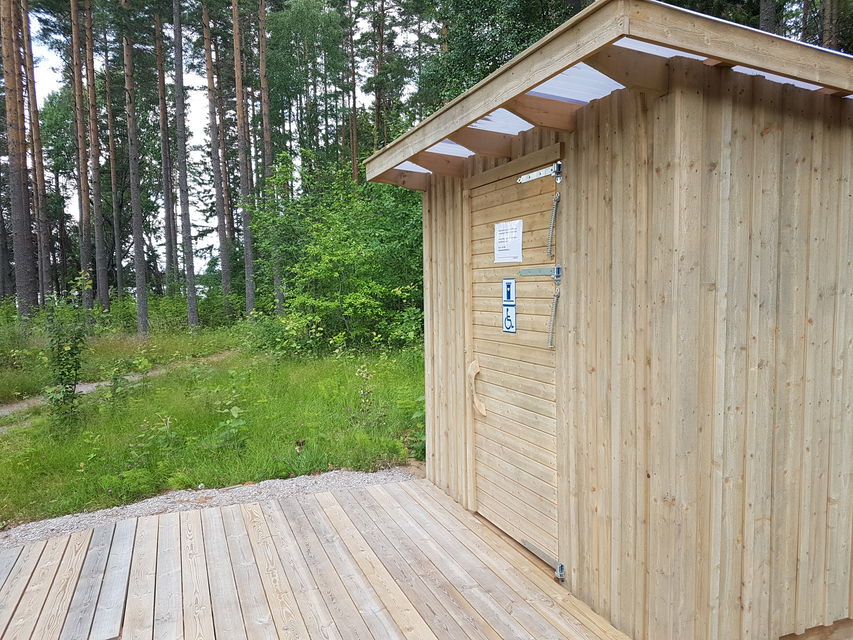 En bred och något brant ramp leder upp till en tillgänglighetsanpassad torrtoalett
