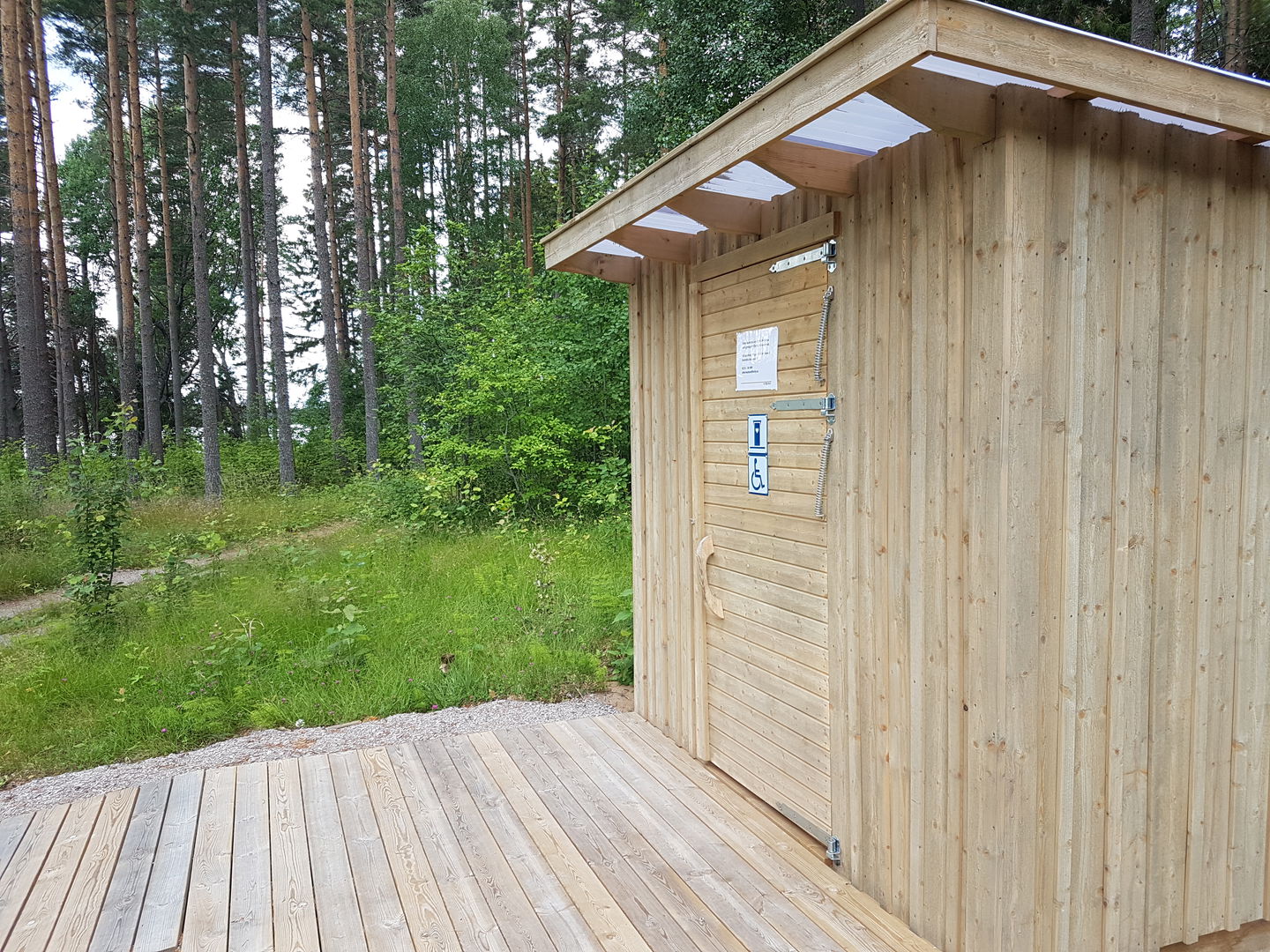 En bred och något brant ramp leder upp till en tillgänglighetsanpassad torrtoalett