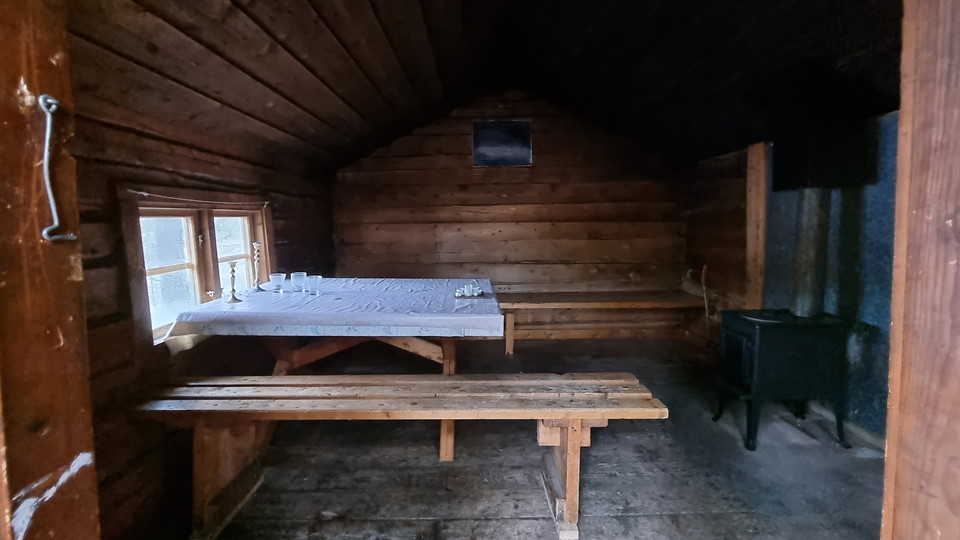 Insidan av en byggnad med bänkar bord och en kamin