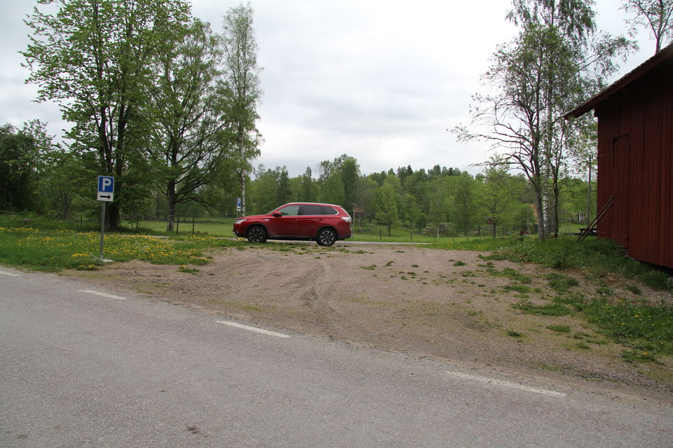 Parkeringsplats med en parkerad bil.