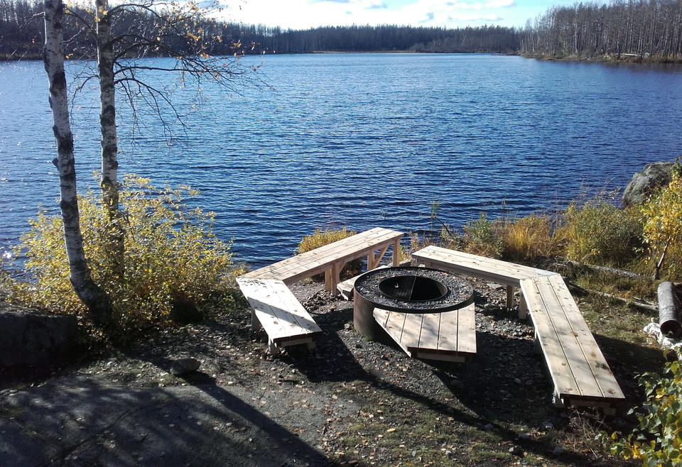 Eldstad med bänkar precis intill vatten.