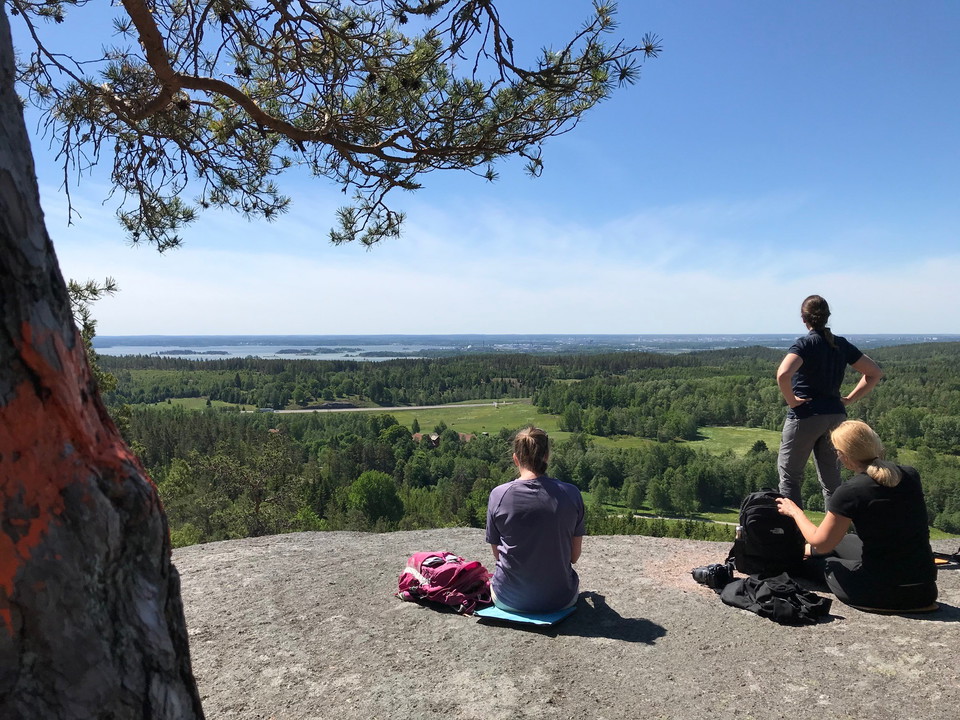 Tre kvinnor på ett berg tittar ut över utsikten