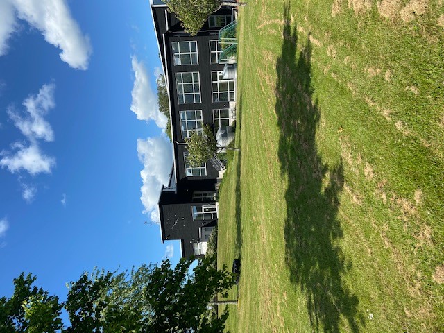 Simhallsbyggnaden med gräsmattor i förgrunden tagit från utebassängerna