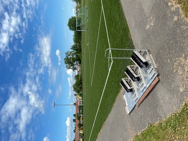 Konstgräsplan med sopstation för granulat i förgrunden