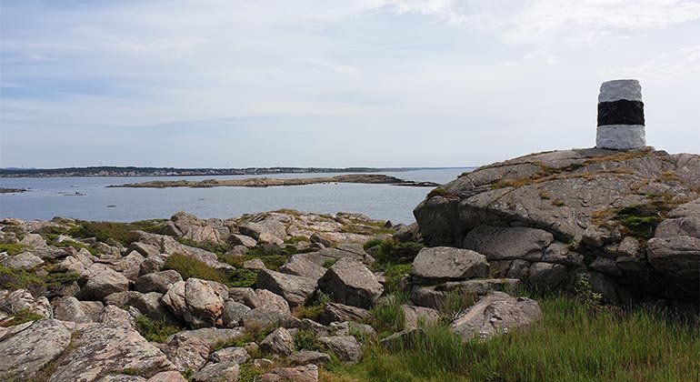 Utsikt från Rödskär med en svart-vitmålad sten i förgrunden.