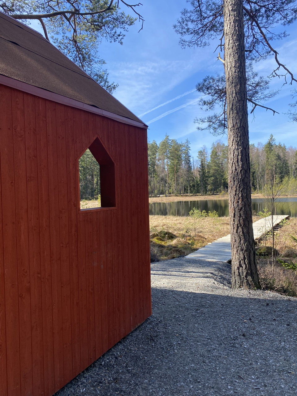 Ett vindskydd intill en spång som går ut i mossen