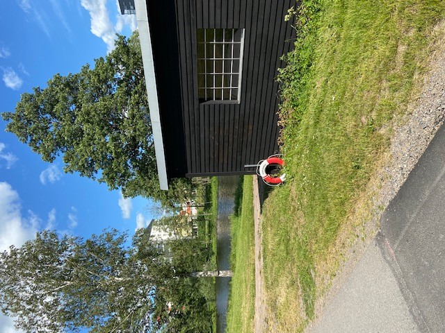 Byggnad i svart färg för förvaring av kanoter som hyrs ut av Lundbybadet