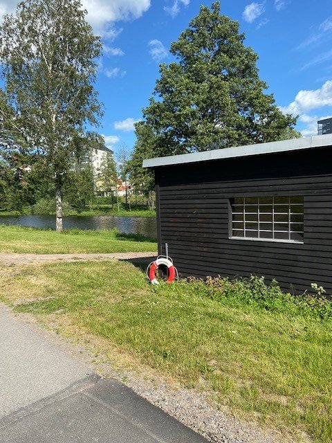 Byggnad i svart färg för förvaring av kanoter som hyrs ut av Lundbybadet