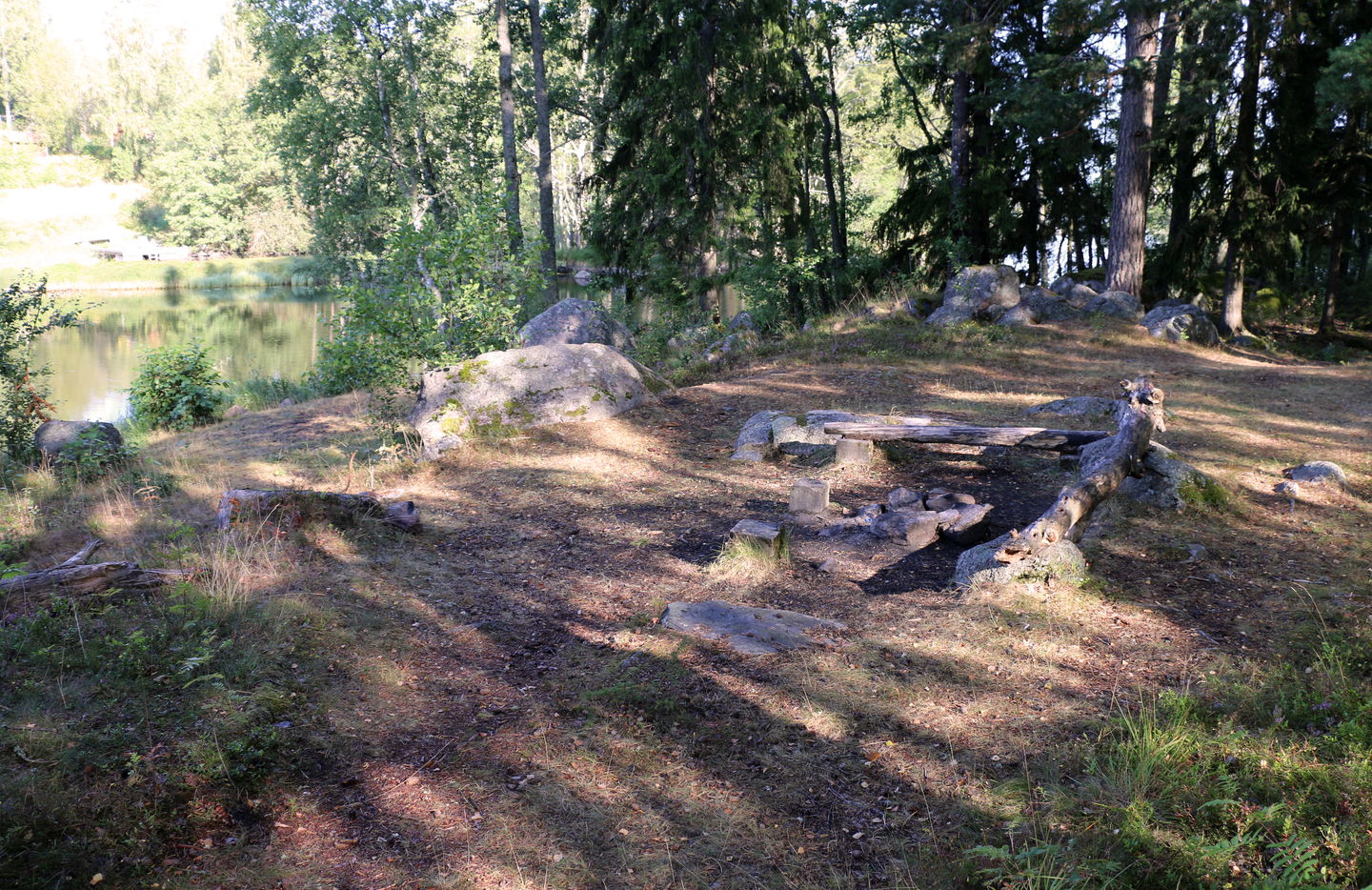En liten eldstad och några bänkar att sitta på vid strandkanten.