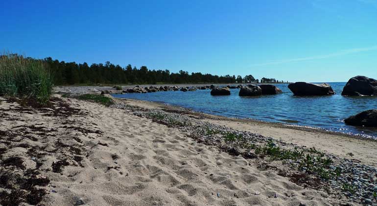 Blå himmel och blått hav vid Snäckens långa sandstrand.