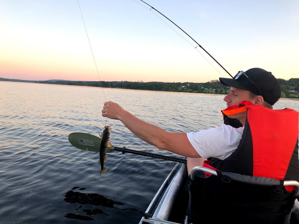 Man i kanot som fiskar