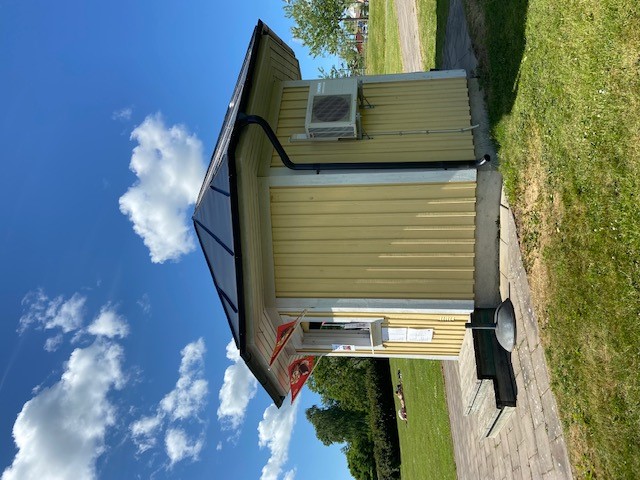 Kioskbyggnad i gul färg med vita knutar. Öppen sommatid