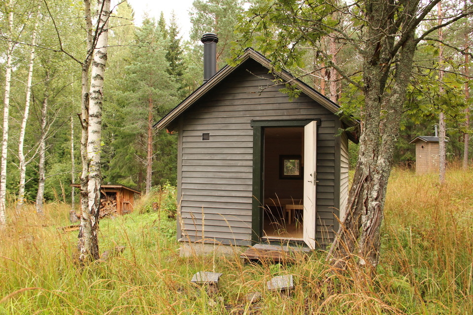 Liten grå stuga med dörren öppen