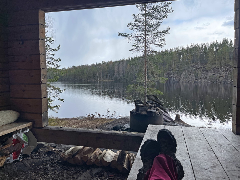 Utsikt över en sjö genom öppningen från ett vindskydd.