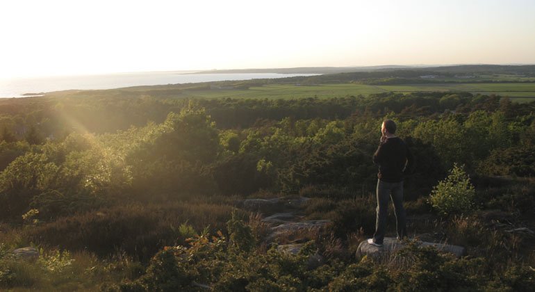 Man som står på utsiktsplats i reservatet och kolla ut över hav och mark
