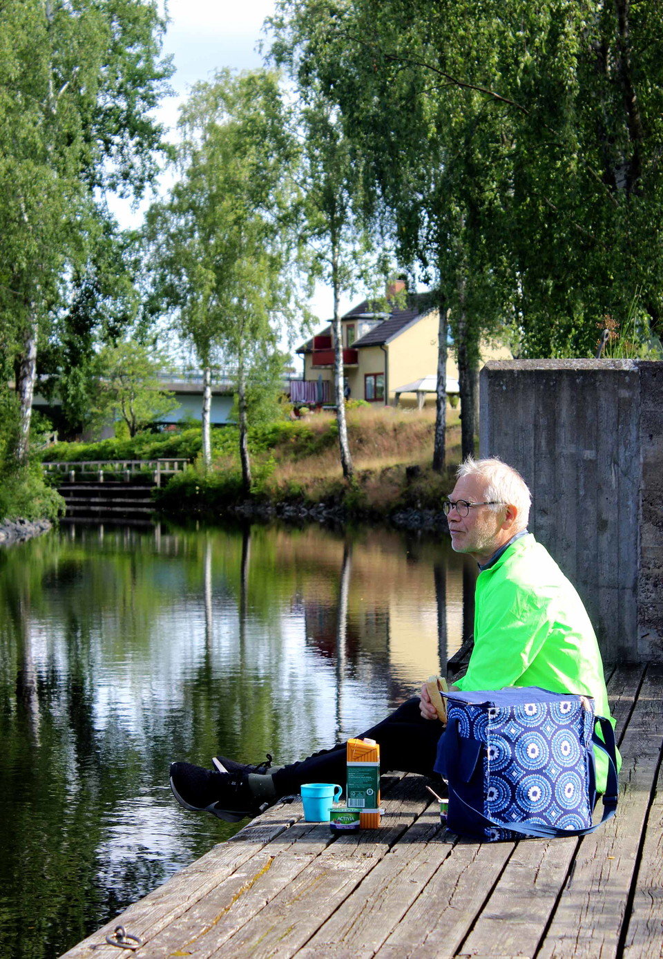 Vilande cyklist äter frukost vid slussen