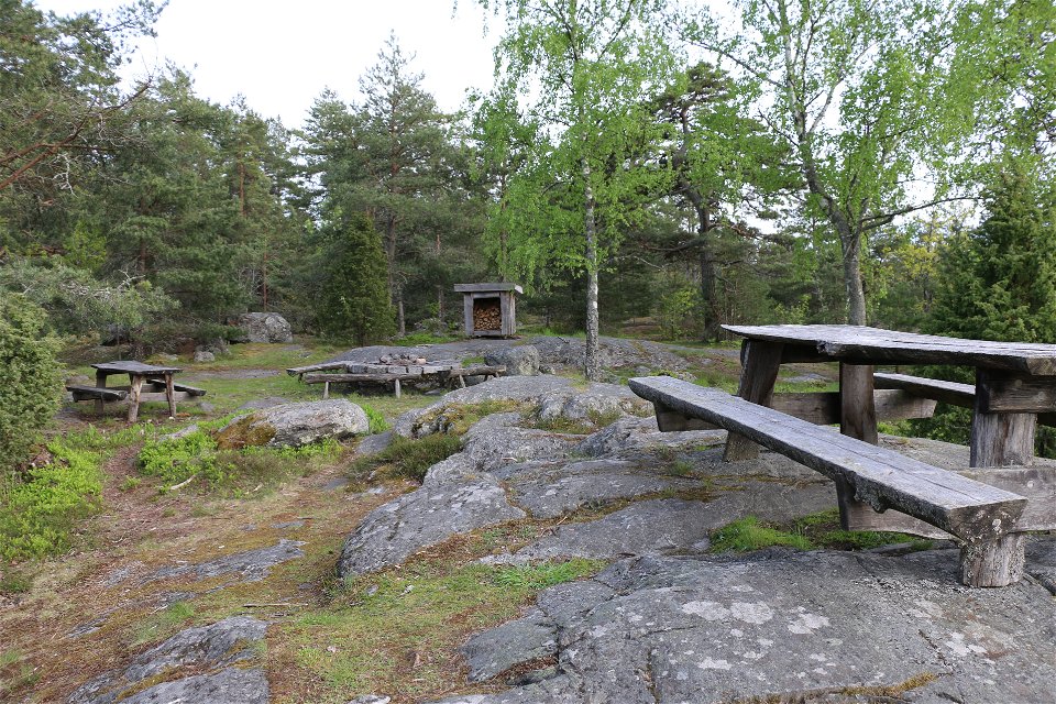 På rastplatsen finns flera bänkar med bord och en grillplats.