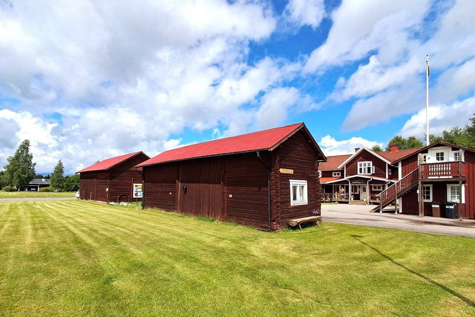 Röda trähus vid grön äng
