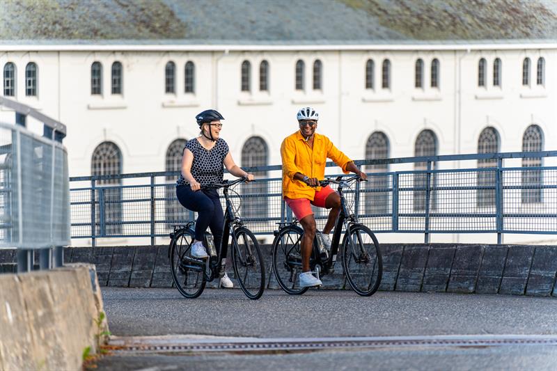 Ett par på sykkeltur inne på kraftstasjon område