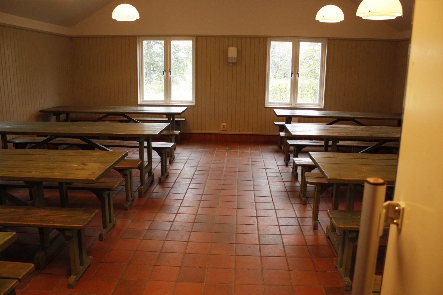 Ett stor rum med flera bänkbord i två rader.