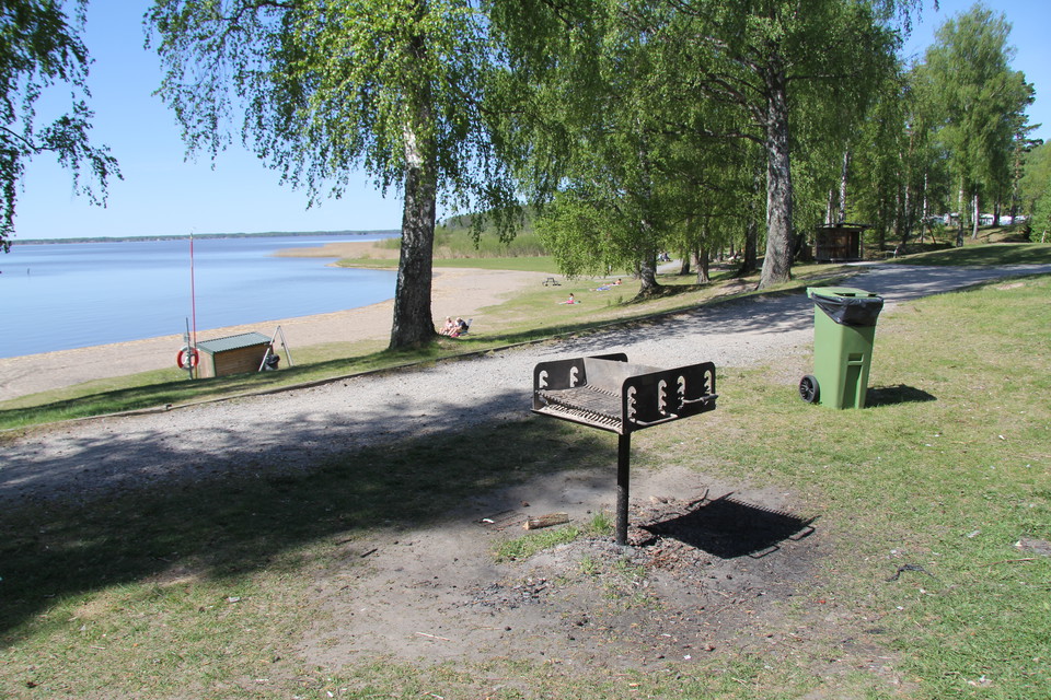 En grill. I bakgrunden syns stranden och Mälaren.