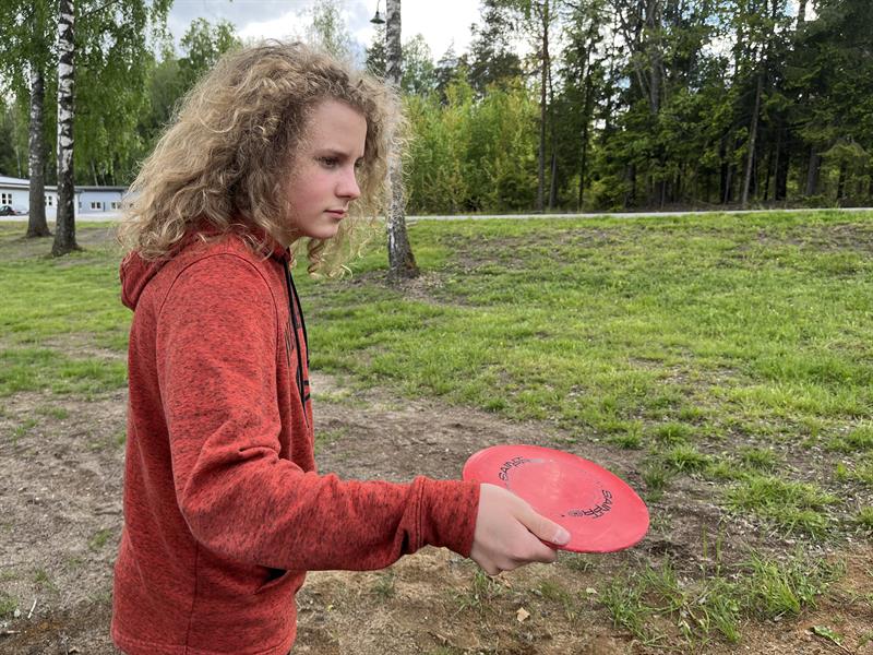 en gutt som spiller frisbeegolf