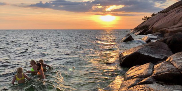 Badande barn i solnedgång