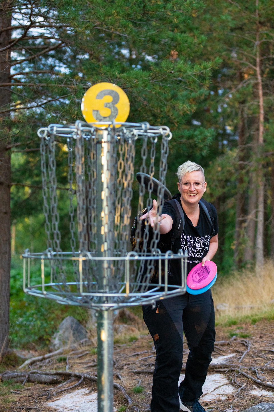 En glad person slänger en disc mot en korg