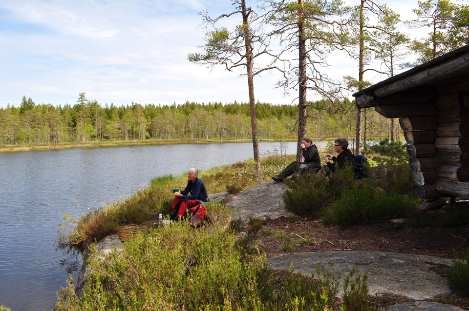 Vindskydd vid vatten med människor som fikar utanför
