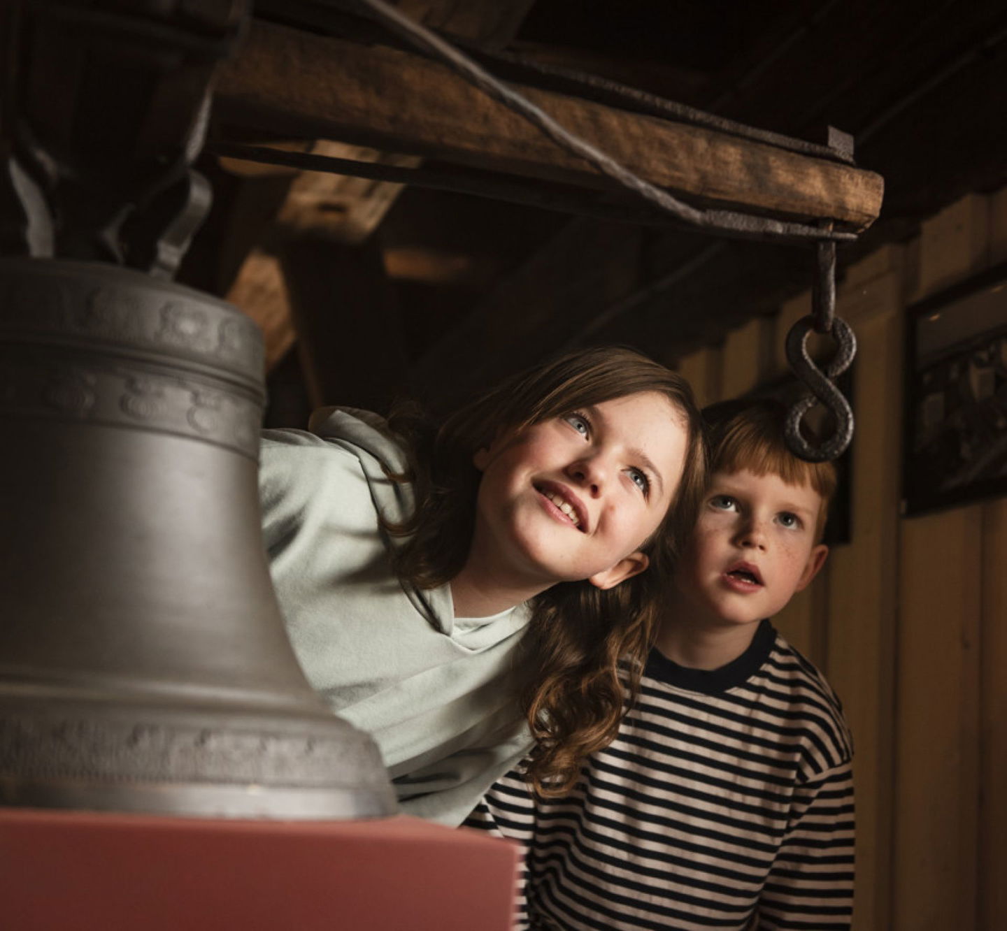 Två barn som nyfiket spanar in en historisk klocka på Kristinehamns Historiska.
