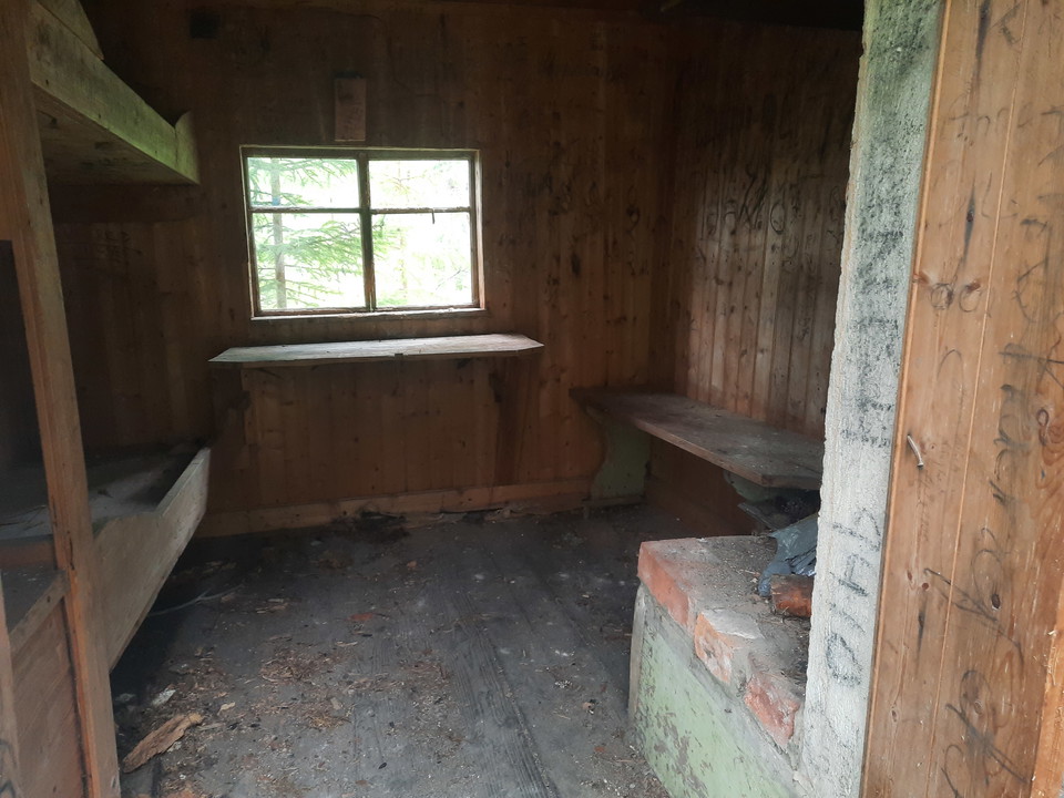 Två korta sängar, en sittbänk och en liten öppen spis finns i kojan