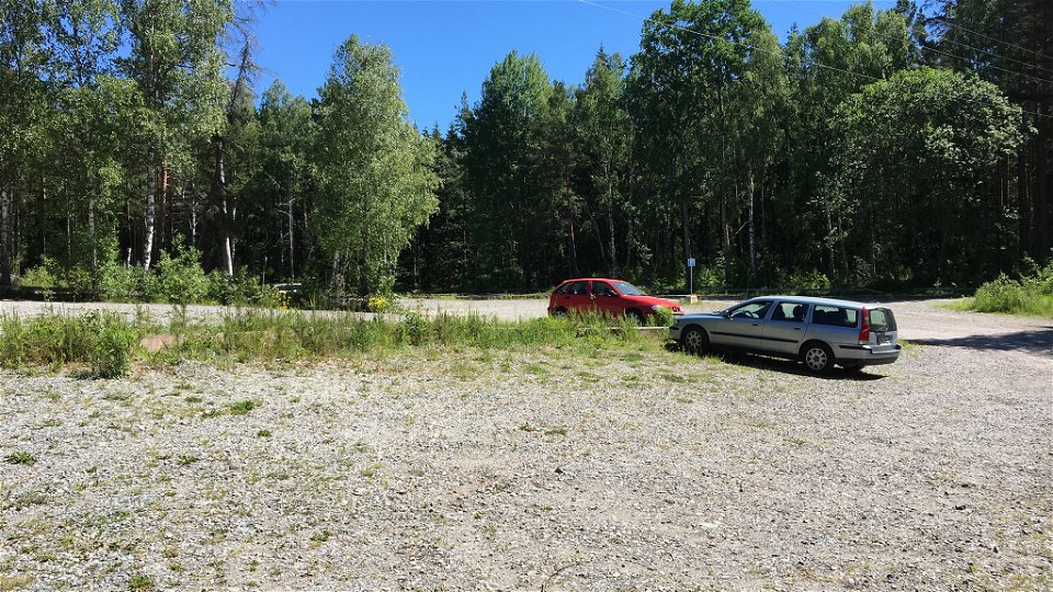 En stor parkeringsplats med två bilar parkerade.