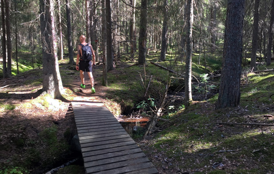 En person med ryggsäck går över en spång.