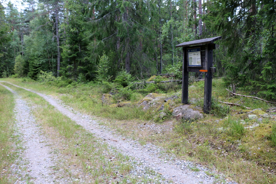 Informationstavlan intill en grusväg.