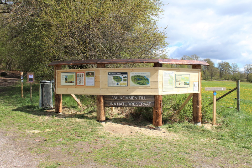 Skyltställ vid parkeringen med information om naturreservatet och stigar
