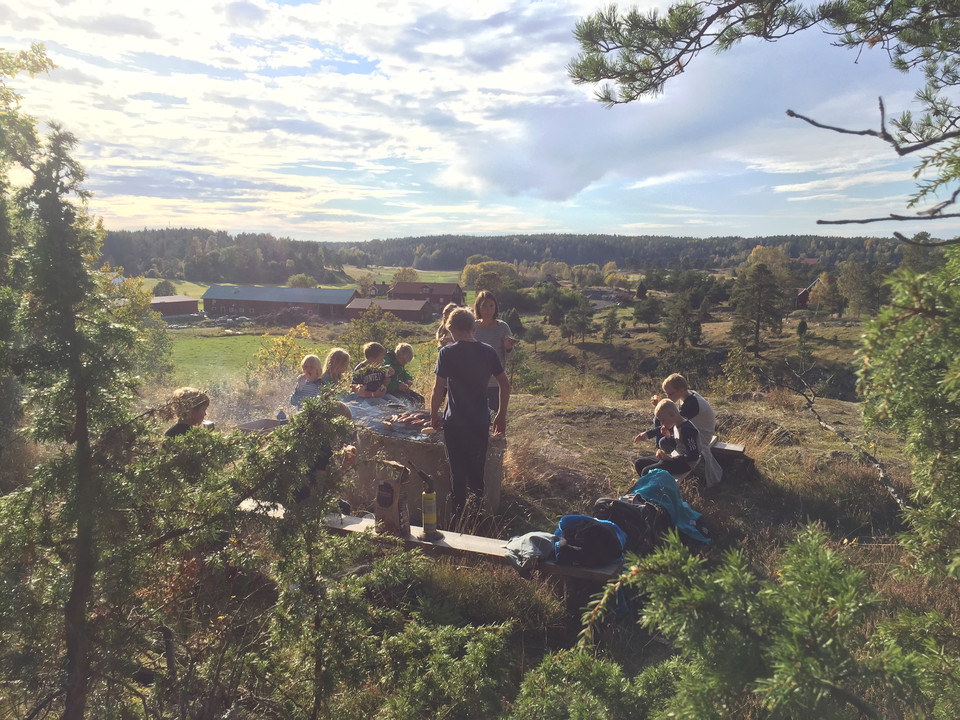 Barn och vuxna grillar på en bergstopp.