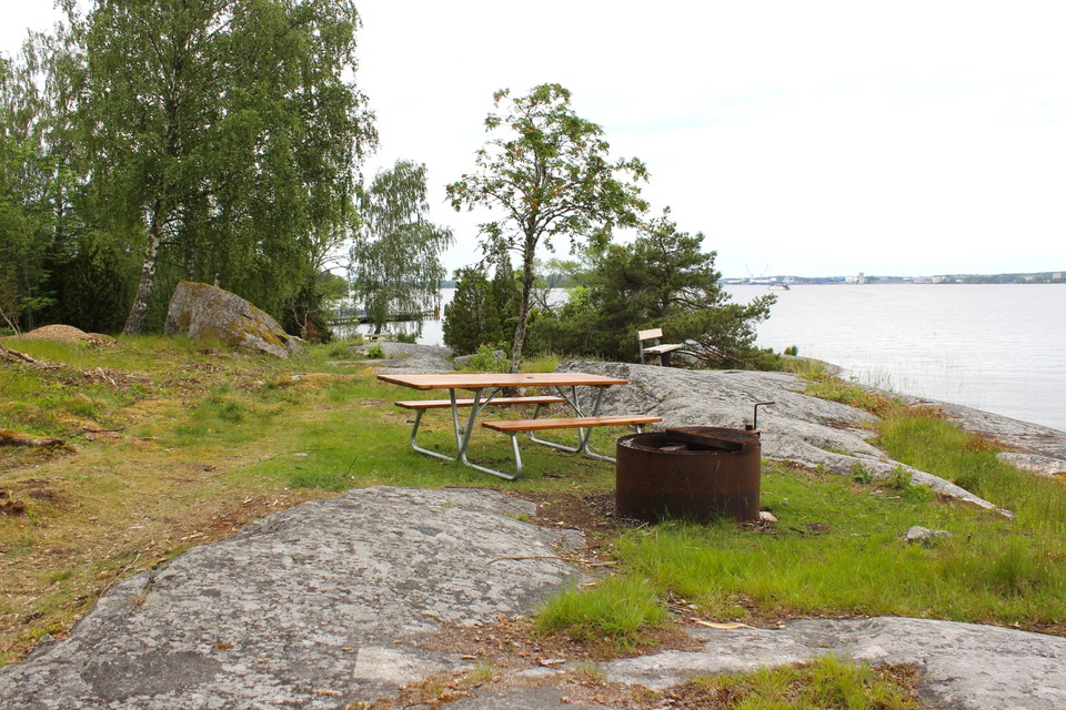 Sittbänk med bord och eldstad med utsikt över Mälaren.