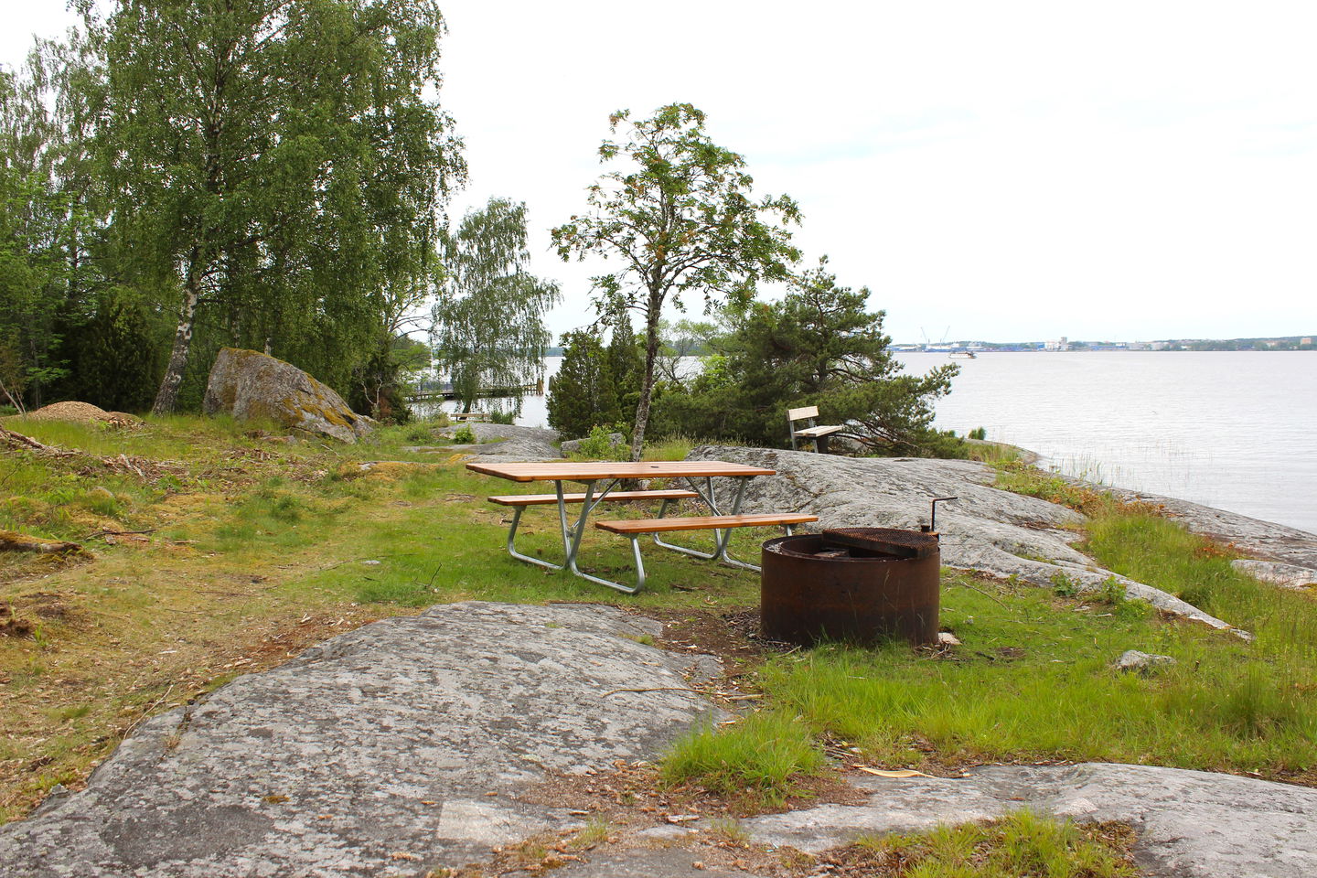 Sittbänk med bord och eldstad med utsikt över Mälaren.