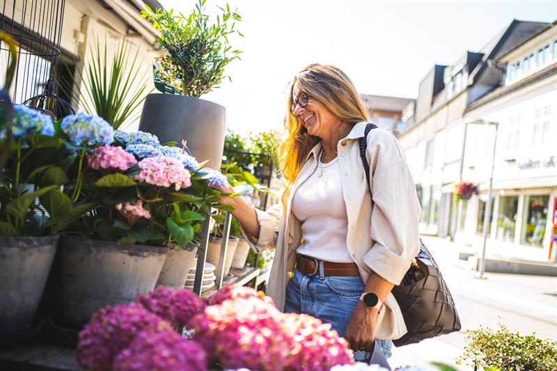 kvinne står å ser på blomster
