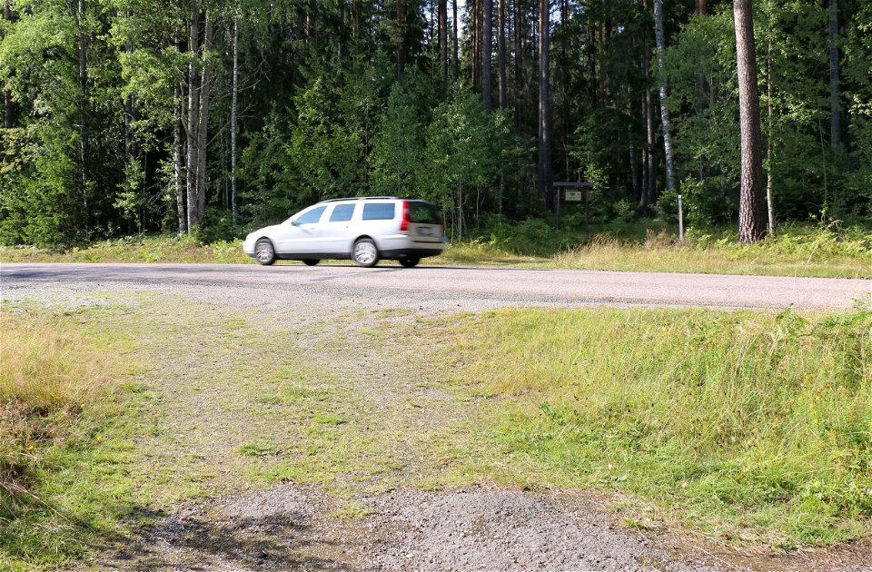 Bil som kör förbi informationstavlan till naturreservatet.