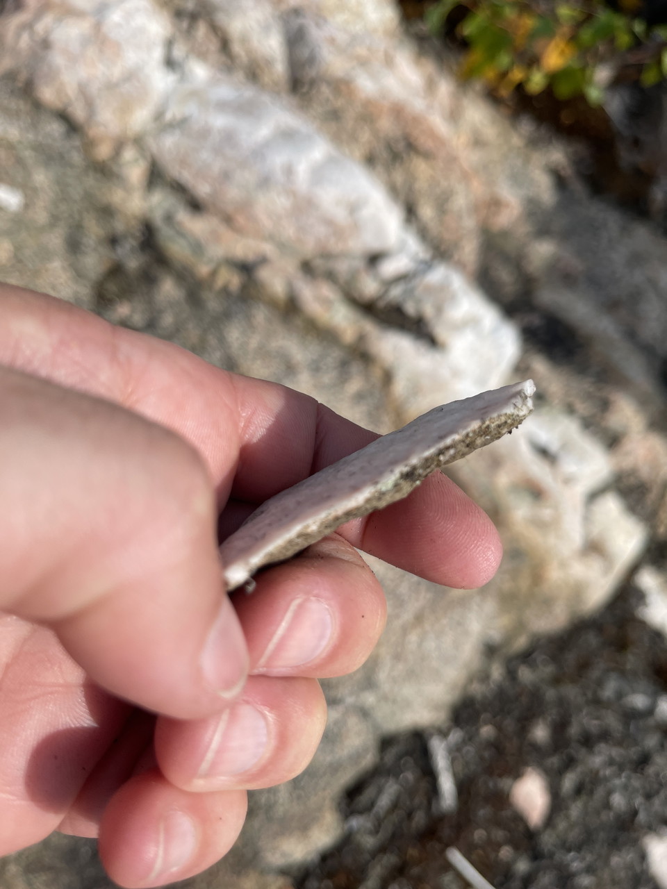 Hand som håller en bit kvartssten.