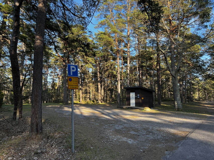 grusparkering med dass i bakgrunden