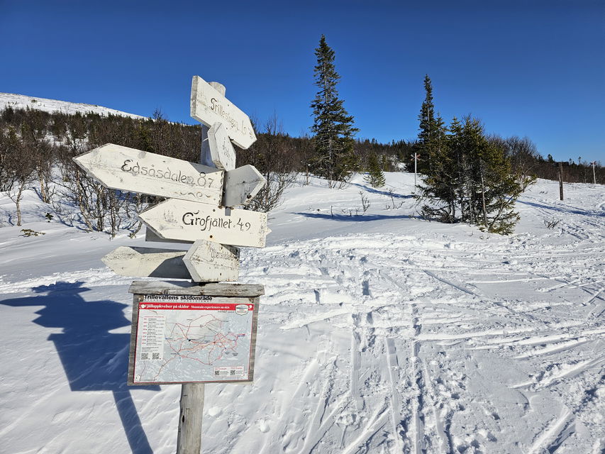 Hänvisningsskyltar som pekar åt olika håll framför snöig mark