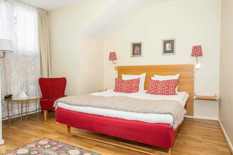 Ett sovrum med en säng och en stol.