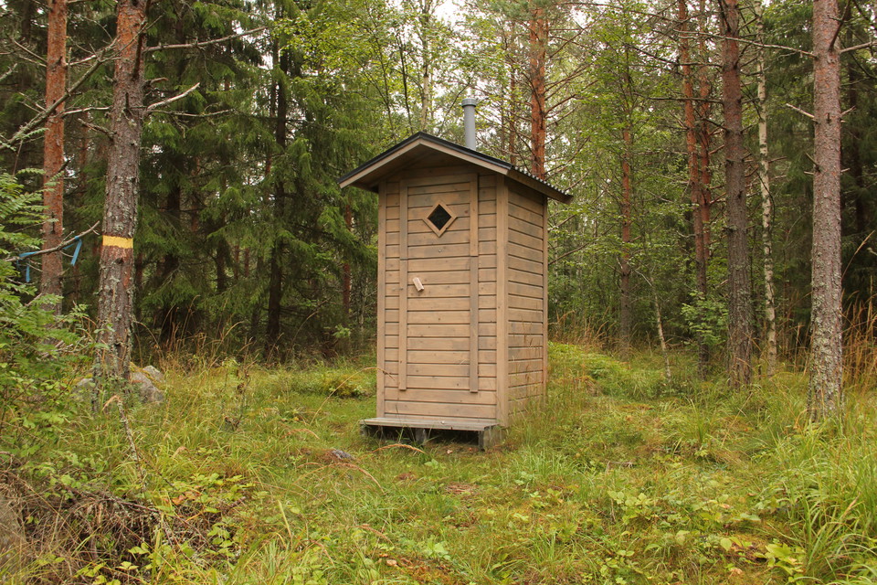 Litet gråfärgat utedass